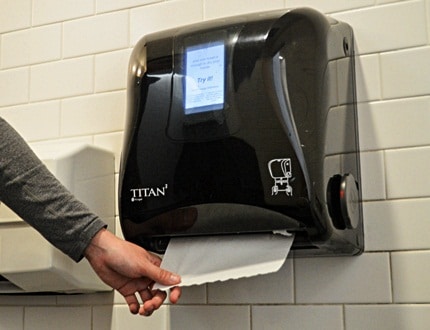 A hand that is pulling a paper towel