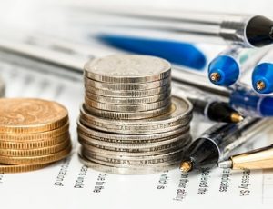 A pile of coins and pens on the table