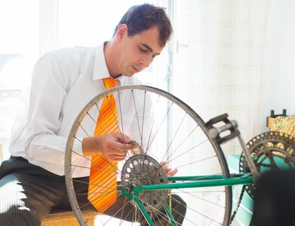 A man holding his bicycle wheel