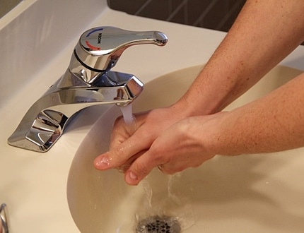 person washing hands with a flowing water