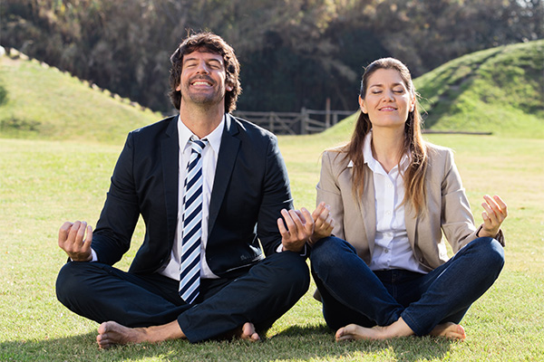 adult man and woman performing a yoga post outdoors