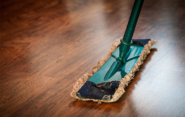 green floor mop and a shiny mahogany floor