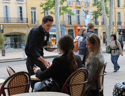 Restaurant waiter serving drinks to the customers