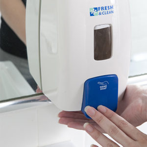 person using the white soap dispenser