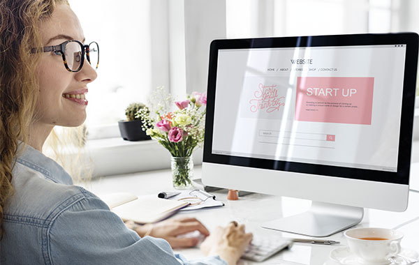 smiling young woman working using her iMac