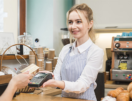 female cashier handing over a payment terminal