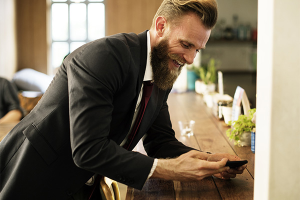 happy male employee using his mobile phone