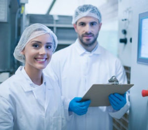 Man and woman wearing white food processing uniform