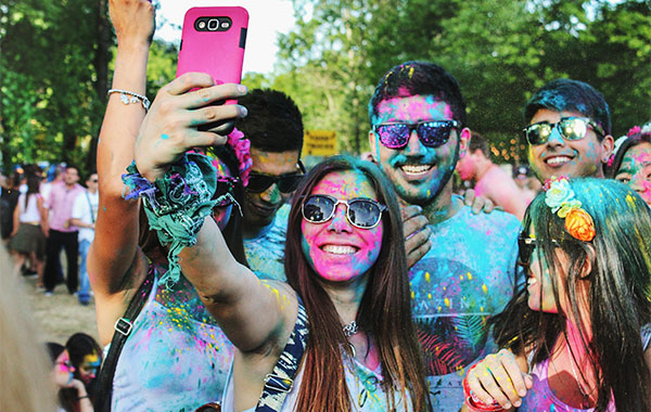 group of people with paint all over their face and shirt taking selfie