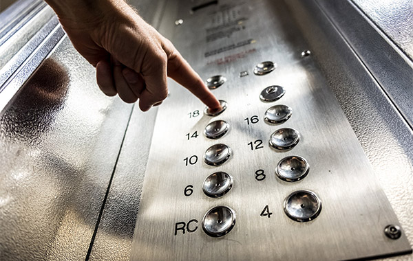 person pushing elevator buttons