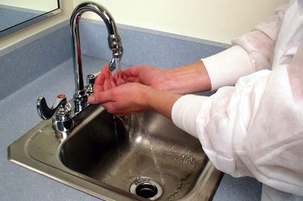 A lab technician washing her hands